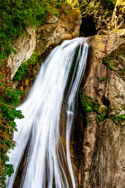 Close view of Twin Falls water sheeting over the top of a rock face into a turquoise pool below